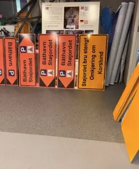 Oransje henvisningsskilt til båthavn og gule omkjøringsskilt for stengt bru, produsert med godkjent refleksfolie.