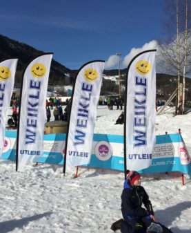 Nærbilde av solide beachflagg fra Reklameverket brukt til profilering under et vinterevent.