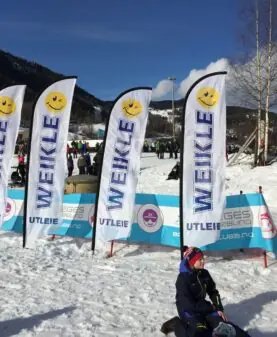 Nærbilde av solide beachflagg fra Reklameverket brukt til profilering under et vinterevent.