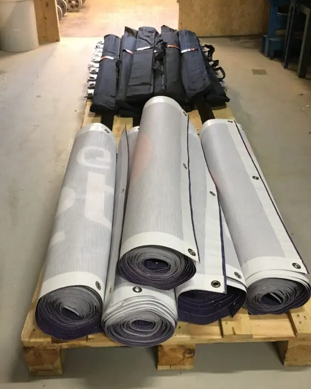 Sammenrullede mesh-bannere på pall, klare for levering