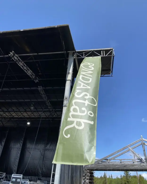 Grønt beachflagg med Rondastak-logo festet til en utescene
