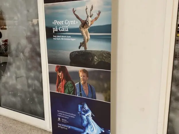 En rollup-banner står på gulvet og viser reklame for Peer Gynt på Gålå med flere bilder fra forestillingen.