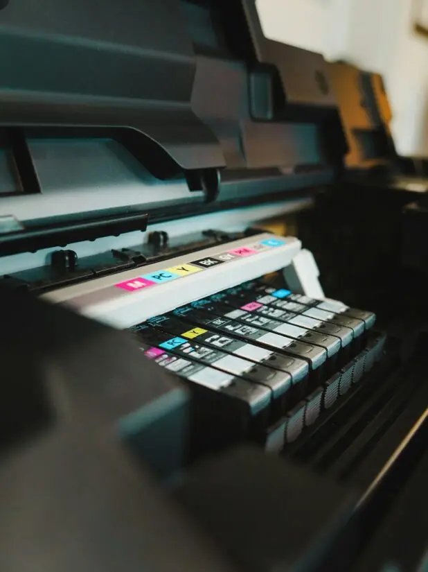Nærbilde av blekkpatroner i CMYK-farger i en åpen printer