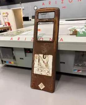 Gamle klistremerker med teksten NEGROC og et diamantformet symbol sitter på et rustent metallpanel.