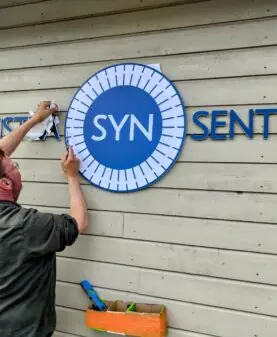 Montør fjerner monteringsmalen etter at logo og fasadebokstaver er festet