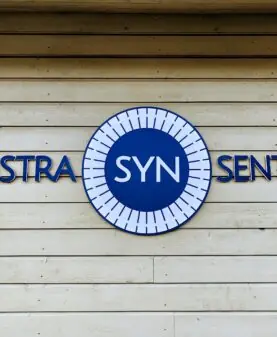 Ferdig montert fasadeskilt med utskjærte bokstaver og logo for Vinstra Synsenter
