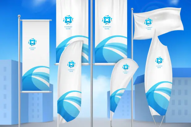 En samling av hvite flagg og bannere i ulike former, prydet med et blått bølgemønster og en logo, står utendørs mot en blå himmel.
